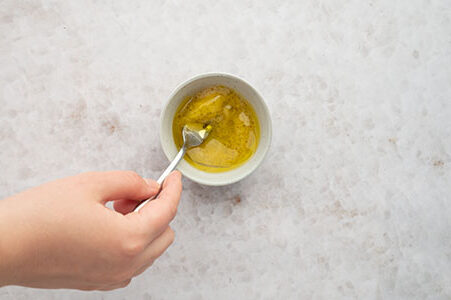 Eine Person rührt das Dressing an.