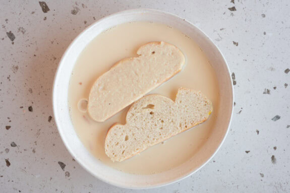 Zwei Scheiben Brot liegen in der Puddingpulver-Masse.