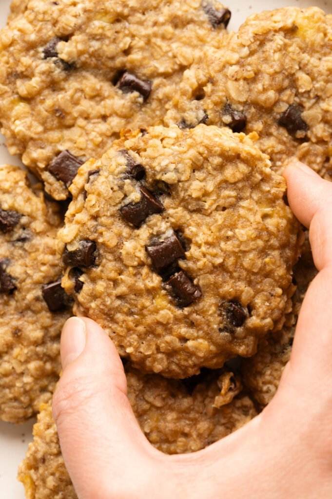 Eine Person nimmt sich einen Bananen-Erdnuss-Keks.