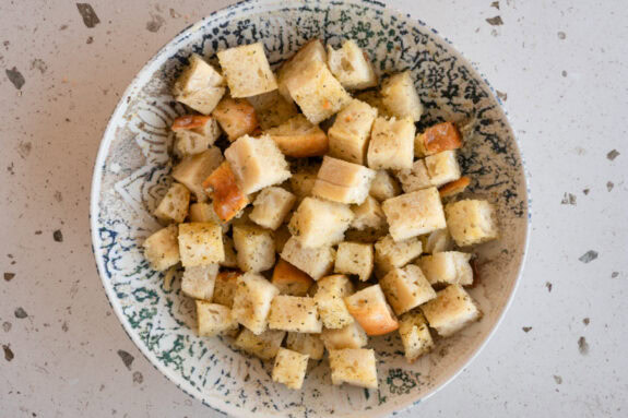 Eine Schüssel mit marinierten Croutons steht auf einem Tisch.
