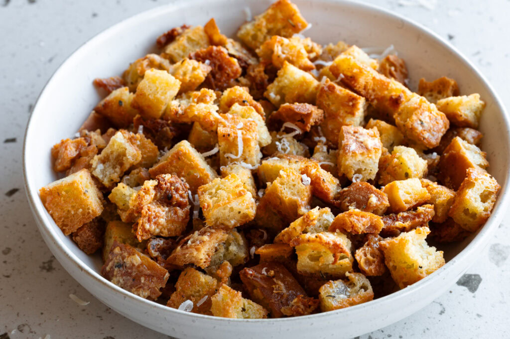 Eine Schüssel mit selbstgemachten Parmesan-Croutons steht auf dem Tisch.