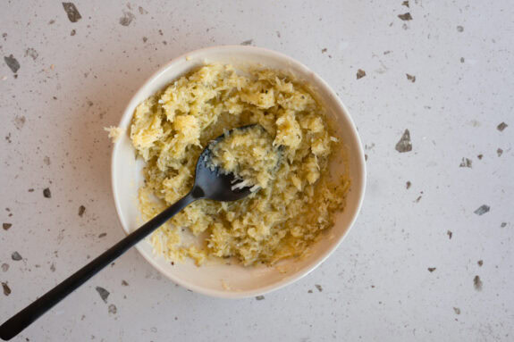 Eine Schüssel mit der Parmesan-Olivenöl-Mischung steht auf dem Tisch.