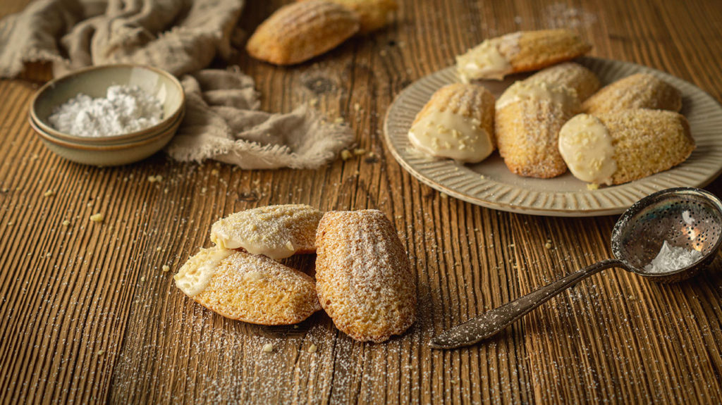 Die Eierlikör-Madeleines liegen auf einem Teller.