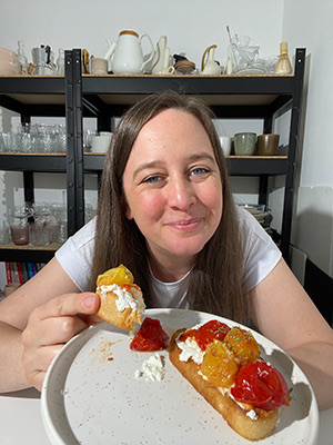 Eine Frau isst die Crostini mit Ricotta.