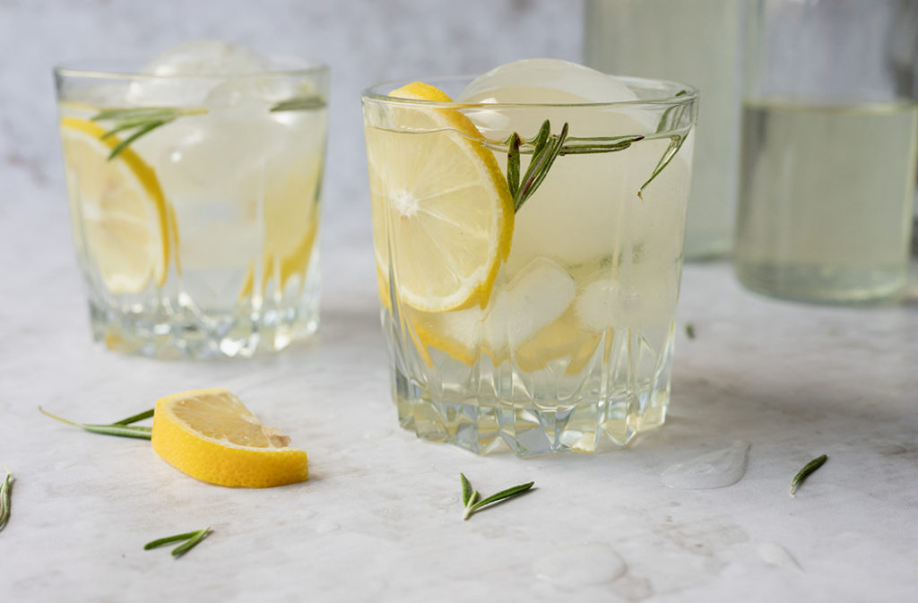 Zwei Gläser mit Rosmarin Zitronen Limonade stehen auf einem Tisch