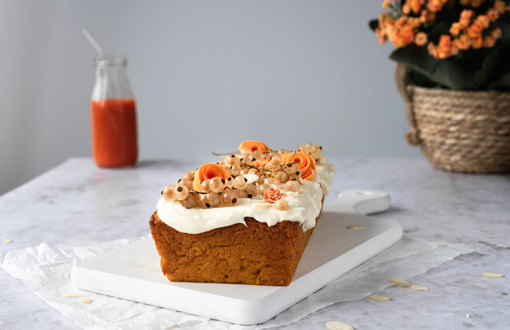 Der Karottenkuchen aus Trester steht auf einem Tisch bereit, um angeschnitten zu werden.