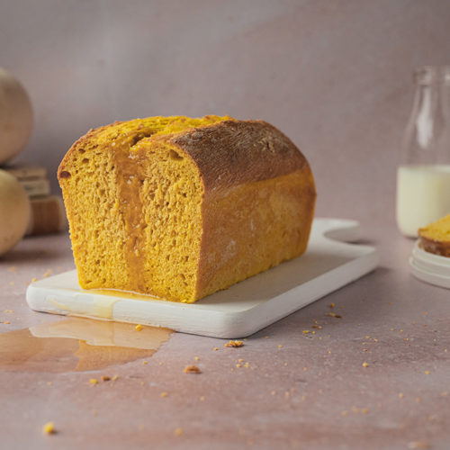 Ein angeschnittenes veganes Kürbisbrot steht auf einem Tisch