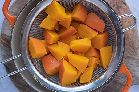 Der gekochte Kürbis ist zum Abtropfen in einem Sieb.
