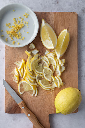 Die klein geschnittene Zitrone liegt auf einem Brett.