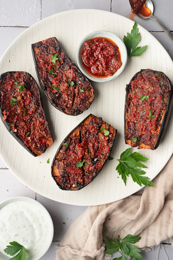 Ein Teller mit vier halben Auberginen.