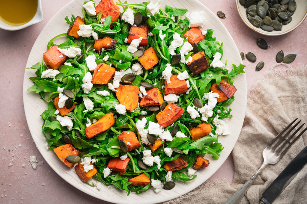 Der Salat mit geröstetem Kürbis und Feta steht auf einem Tisch.