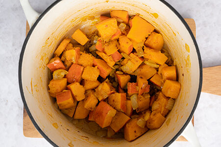 Der Kürbis wird mit den Gewürzen in einem Topf angebraten.