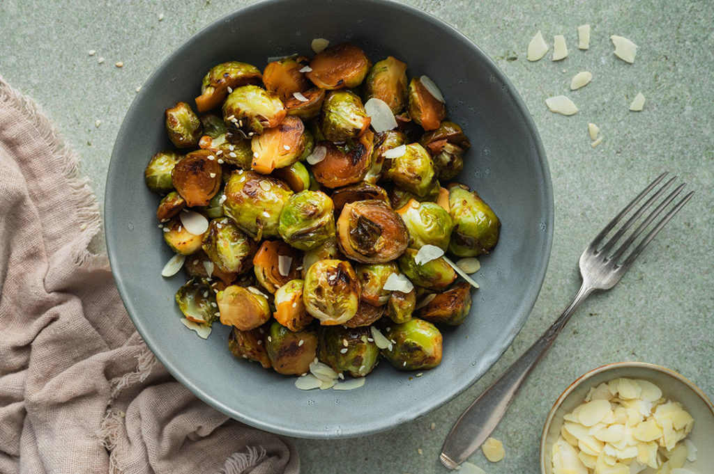 Rosenkohl aus der Pfanne wird auf einem Teller serviert.