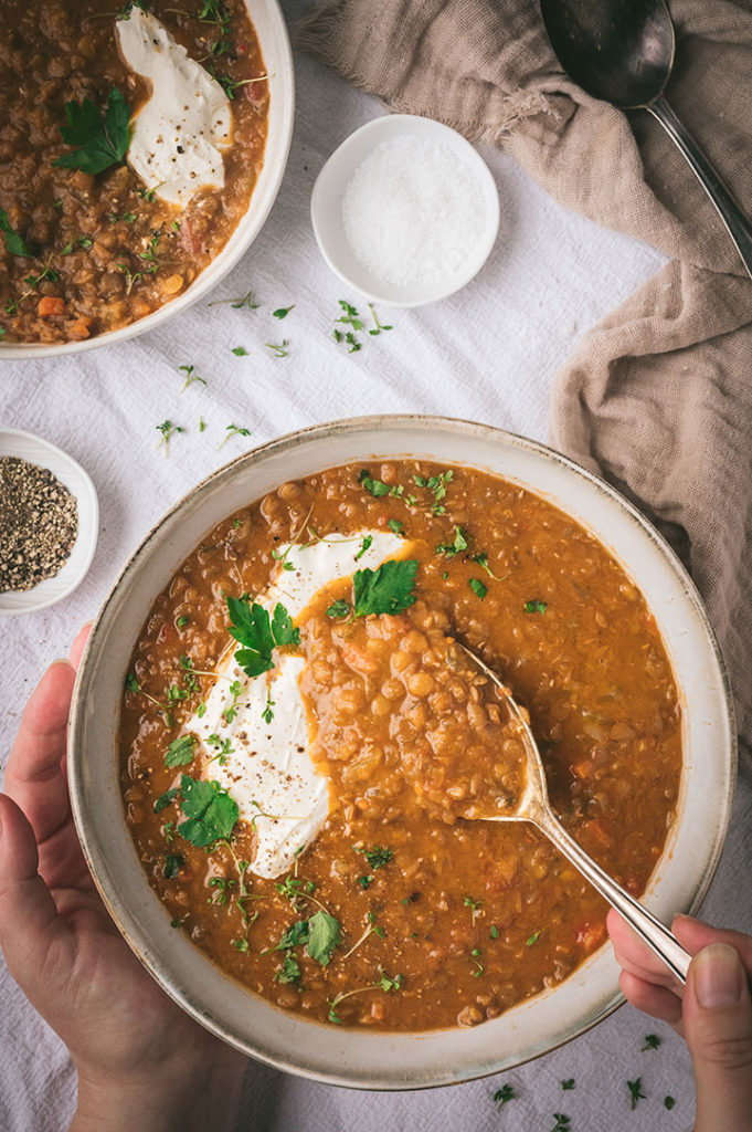 Eine Person isst die Linsensuppe ohne Kartoffeln.