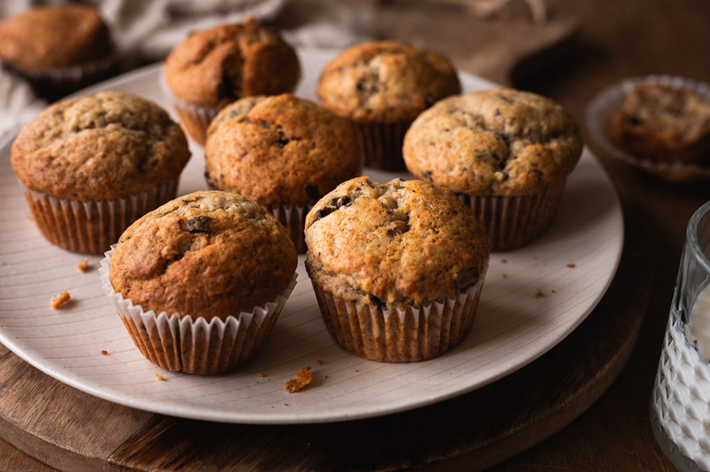 Ein Teller mit saftigen Bananenbrot-Muffins steht auf dem Tisch.