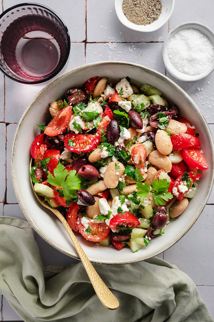 Ein gedeckter Tisch mit griechischem Bohnensalat.