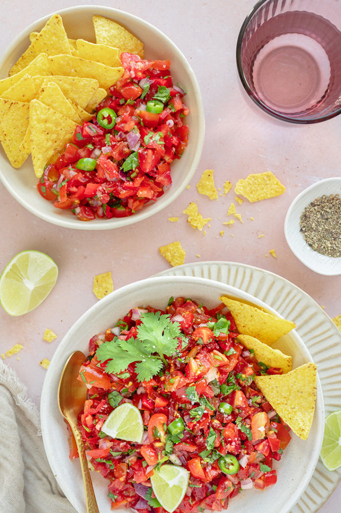 Zwei Teller mit mexikanischer Tomatensalsa mit Nachos stehen auf einem Tisch