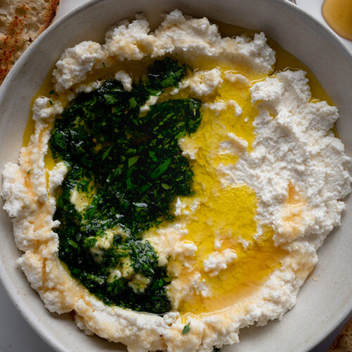 Eine Schale mit Ricotta und Honig steht auf dem Tisch.