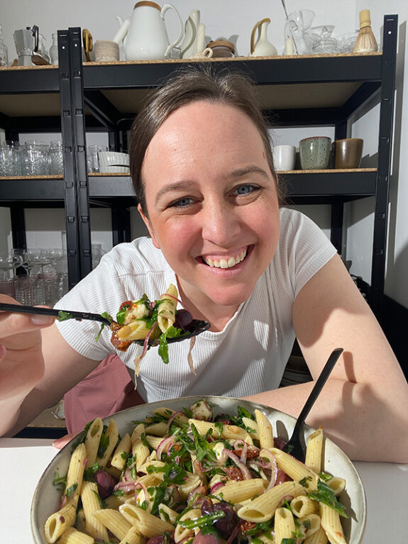 Eine Frau isst den italienischen Nudelsalat direkt aus der Schüssel.