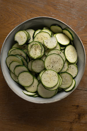 Die gehobelte Zucchini wird mit Salz und Pfeffer gewürzt.