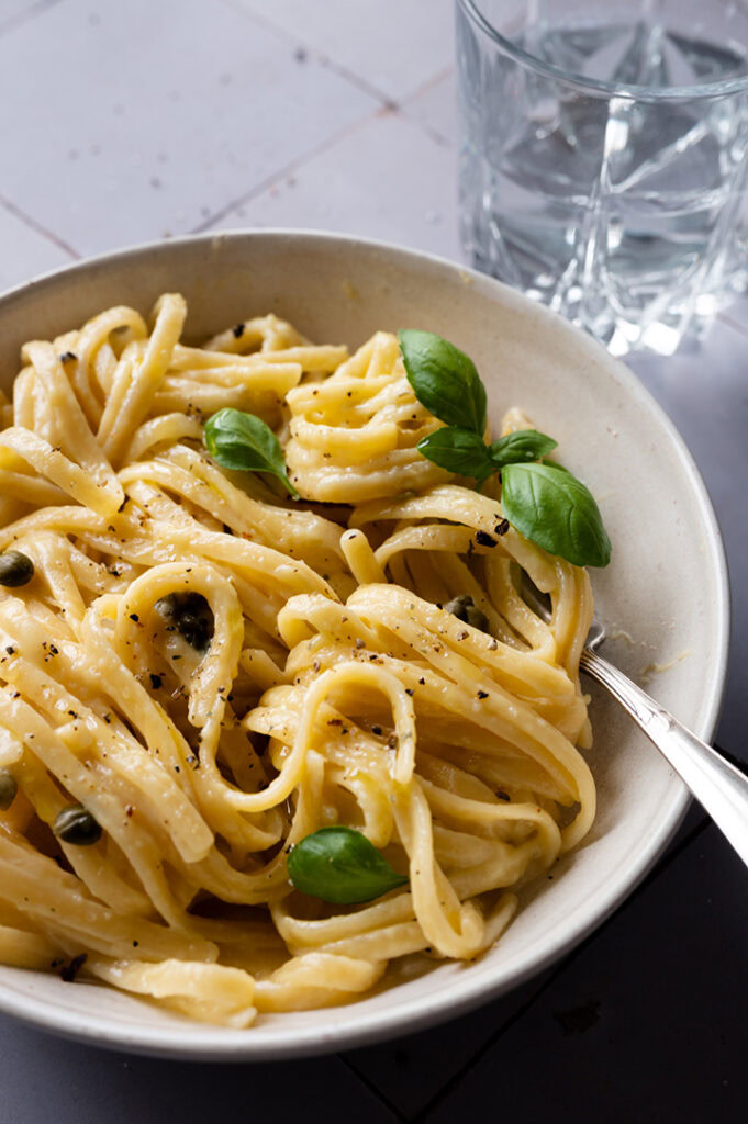 Eine große Portion mit vegetarischen Spaghetti Carbonara stehen auf einem Tisch.