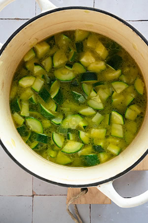 Die Zucchini wird in der Brühe gekocht.