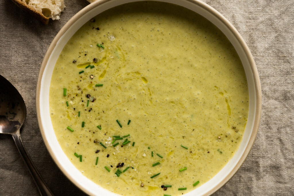 Eine große Schüssel mit Brokkoli Käse Suppe steht auf dem Tisch.