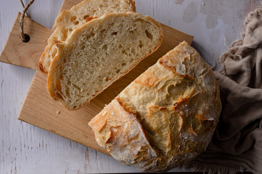 Ein knuspriges Brot liegt auf einem Brettchen.