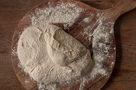 Der Teig wird auf einer bemehlten Fläche ausgebreitet und zur Mitte hin gefaltet.