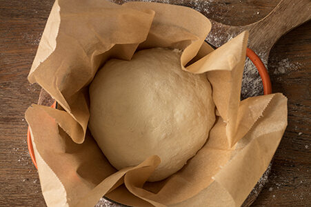 Das Brot wird in einen gusseisernen Topf mit Backpapier gelegt.