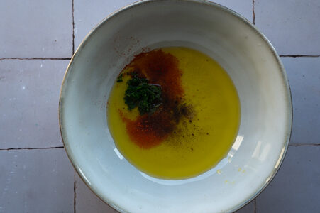 Öl und Gewürze werden in einer Schüssel vermengt.