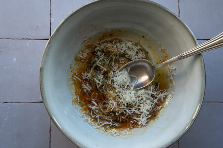 Der Parmesan wird zu dem Öl gegeben.