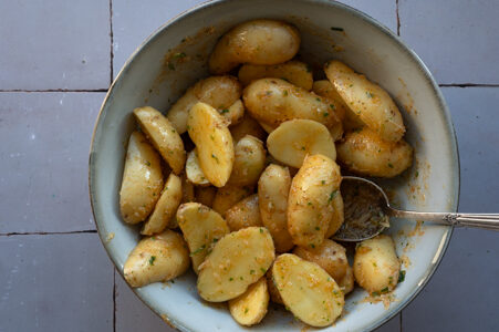 Die Kartoffeln werden zu der Öl-Mischung gegegeben.