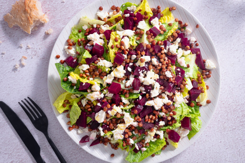 Ein großer Teller mit Linsensalat steht auf dem Tisch.