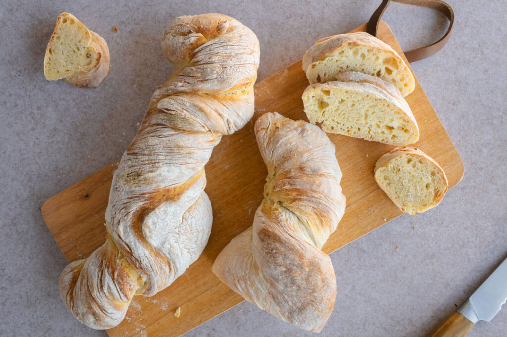 Zwei Wurzelbrote liegen auf einem Brettchen.