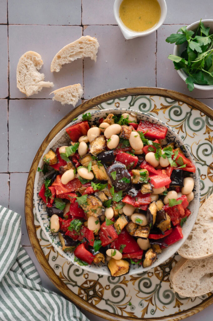 Ein gedeckter Tisch mit einer Schüssel voll  Auberginensalat und Brot.