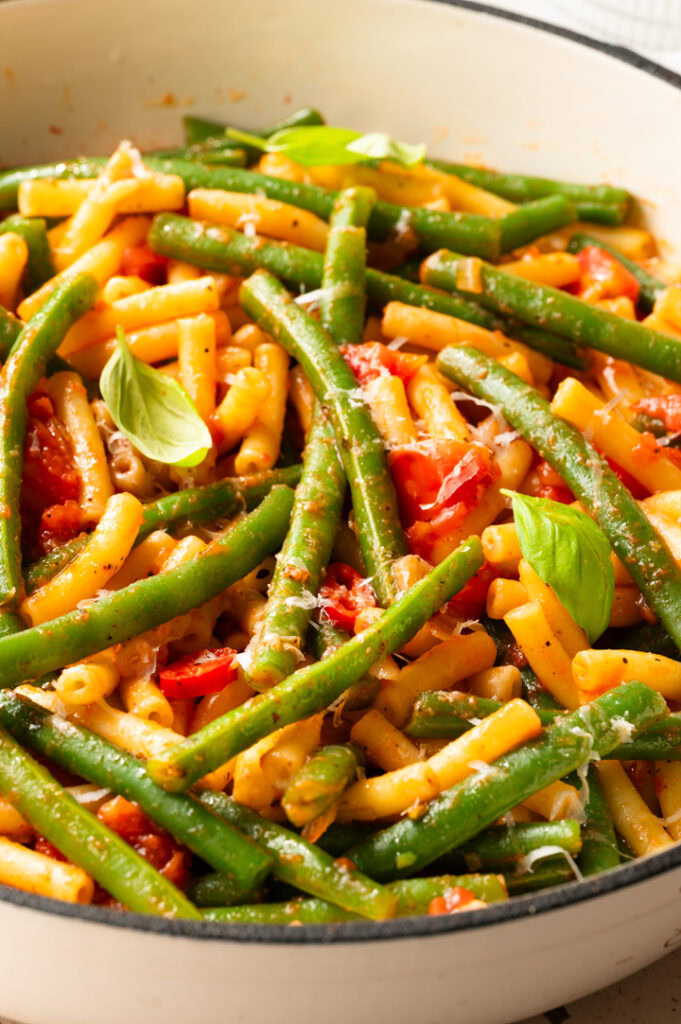 Eine Pfanne mit Pasta mit grünen Bohnen steht auf dem Tisch.