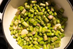 Der Knoblauch und der Spargel werden in einer Pfanne in Butter gegart.