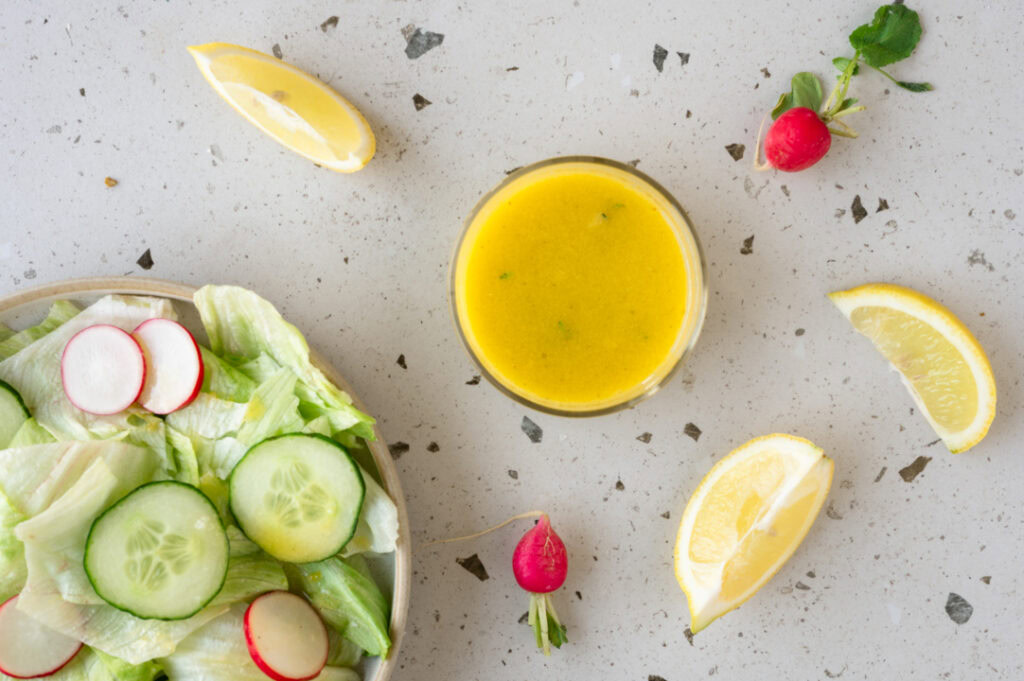 Die Zitronen Vinaigrette wird auf den Salat gegeben.
