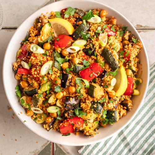 Eine Schüssel mit mediterranem Couscous Salat steht auf einem Tisch.