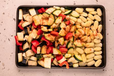 Gnocchi und Gemüse sin auf einem Backblech.