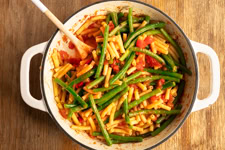 Pasta und Sauce werden vermengt.