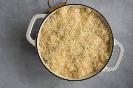 Der Bergkäse wird fein gerieben über die Kartoffeln gegeben.