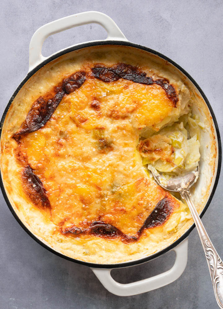 Das Gratin mit Käse wird mit einem Löffel serviert.