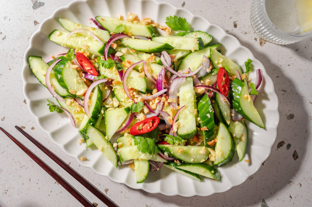 Eine Platte mit thailändischem Gurkensalat und Chilis,