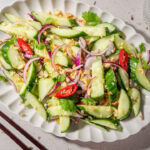 Eine Platte mit thailändischem Gurkensalat und Chilis,