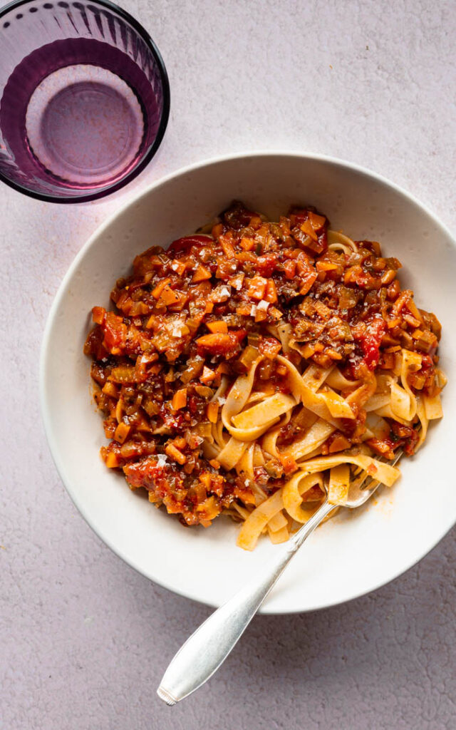Ein gedeckter Tisch mit einer Schüssel voller Veggie Bolognese Toskanischer Art