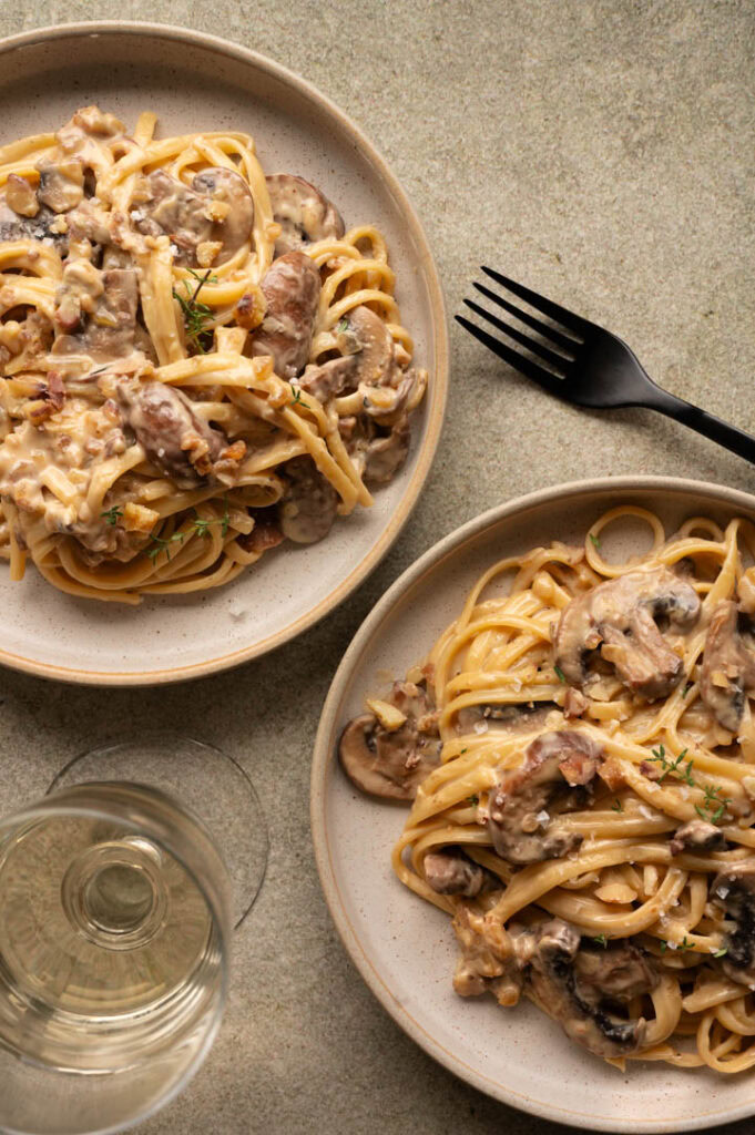 Zwei Teller mit Bandnudeln in Maronen-Sauce.