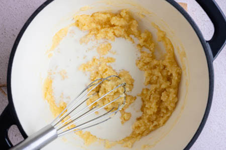 Die Milch und Sahne werden nach und nach in den Topf gegeben.