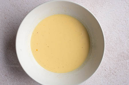 Eigelb und Sahne werden in einer Schüssel verquirlt.